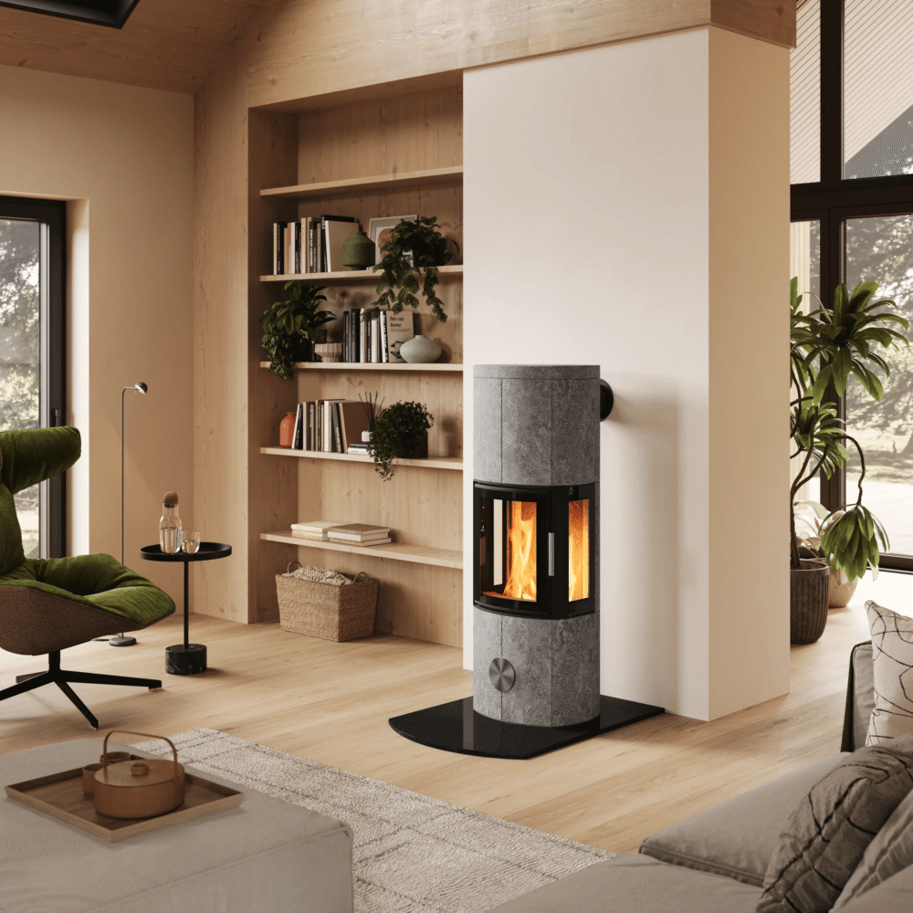 Ein moderner Specksteinofen, zentral platziert in einem hellen, skandinavischen Interieur mit Holztreppe, Sitzecke und Kaffeeservice im Vordergrund.