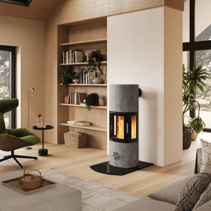 Ein moderner Specksteinofen, zentral platziert in einem hellen, skandinavischen Interieur mit Holztreppe, Sitzecke und Kaffeeservice im Vordergrund.